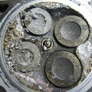 defekter Zylinderkopf mit eingearbeiteten Kolben-Stückchen
